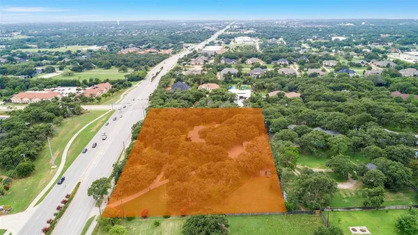 an aerial view of residential houses with outdoor space and trees