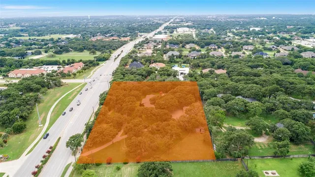 an aerial view of residential houses with outdoor space and trees