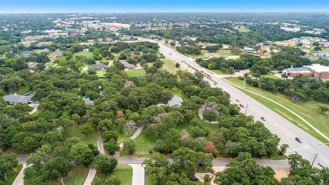 an aerial view of residential houses with outdoor space and trees