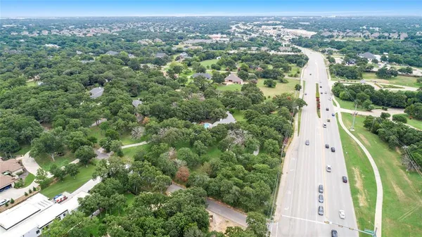 an aerial view of residential houses with outdoor space and trees