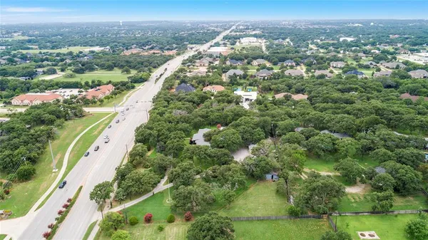 an aerial view of residential houses with outdoor space and trees
