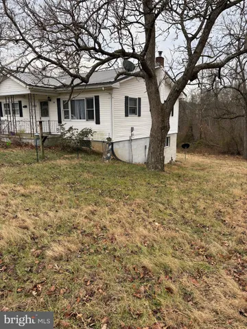 a white house that has a tree in front of it