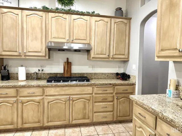 a kitchen with kitchen island granite countertop wooden cabinets and counter space