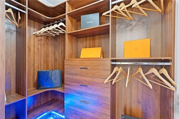 a view of walk in closet with clothes and shoes