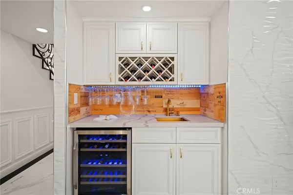 a dining room with furniture a kitchen and chandelier