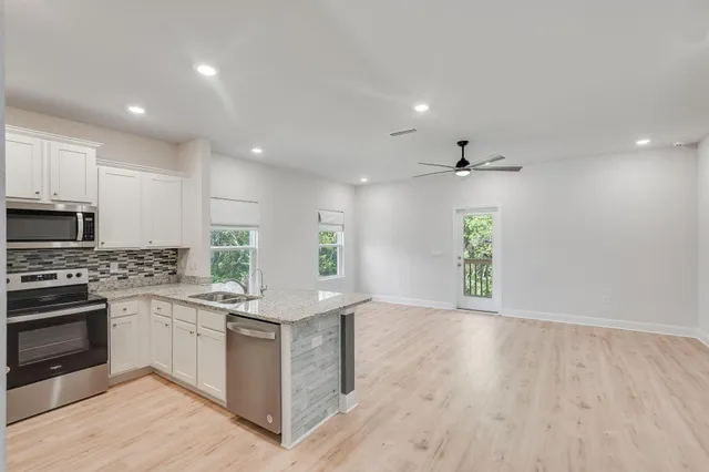 a kitchen with stainless steel appliances granite countertop a stove top oven and sink