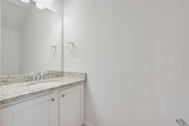 a bathroom with a granite countertop sink and vanity