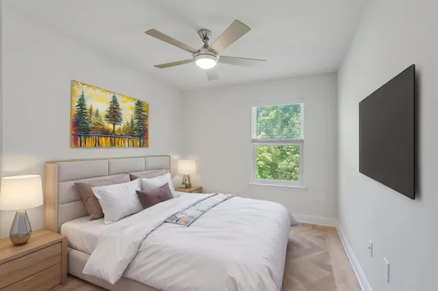 a bedroom with bed tv and a window