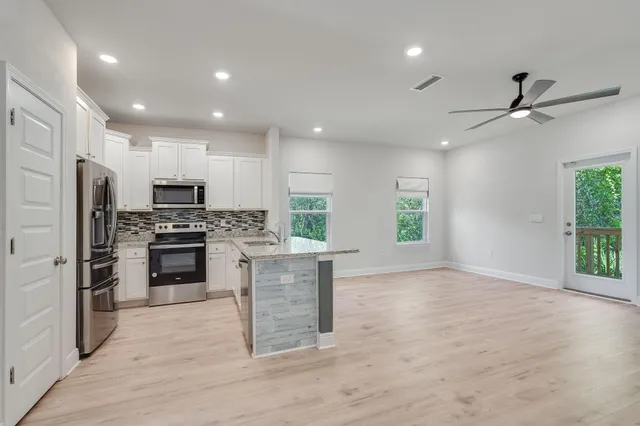 a kitchen with a refrigerator and a stove top oven