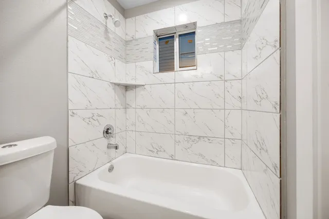 a white bath tub sitting next to a white toilet