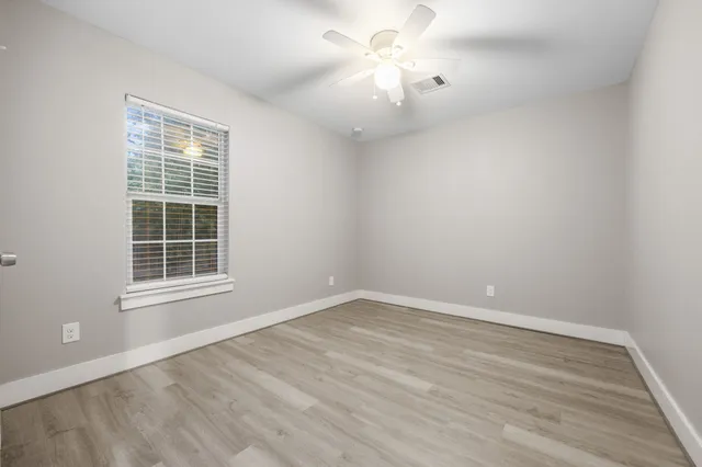 wooden floor in an empty room with a window