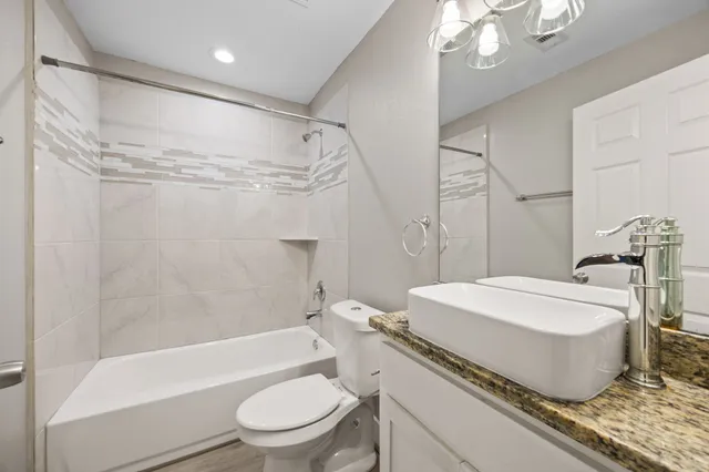 a bathroom with a sink a toilet a mirror and a shower