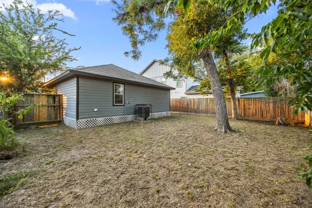 a view of house with wooden stairs and a small yard