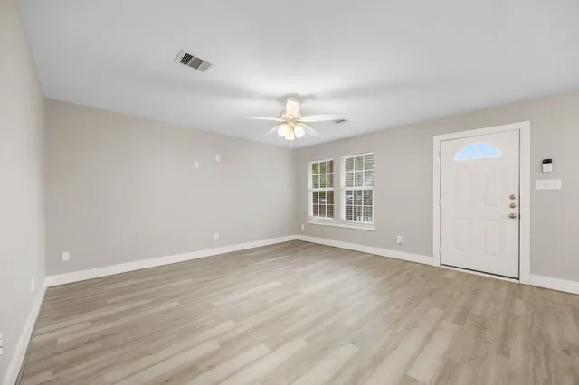 wooden floor in an empty room with a window