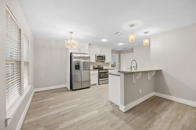 a view of kitchen with cabinets and refrigerator