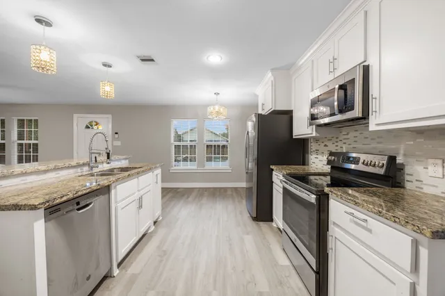a kitchen with stainless steel appliances granite countertop a stove and a sink