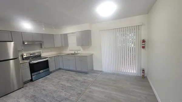a large kitchen with a stove a sink and a refrigerator