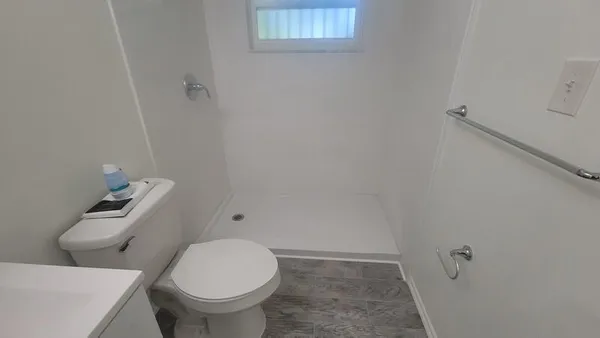 a white toilet sitting next to a white sink and vanity
