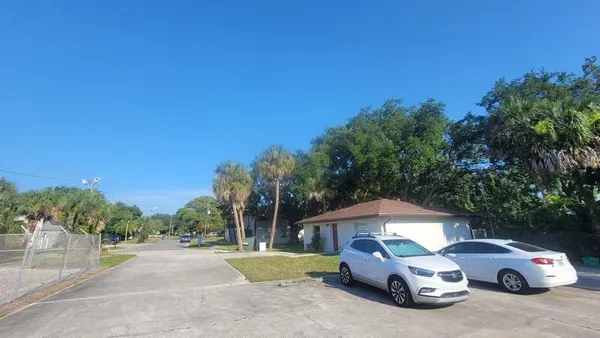 a car parked in front of a house with a yard
