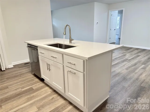 a kitchen with granite countertop a sink stainless steel appliances and cabinets