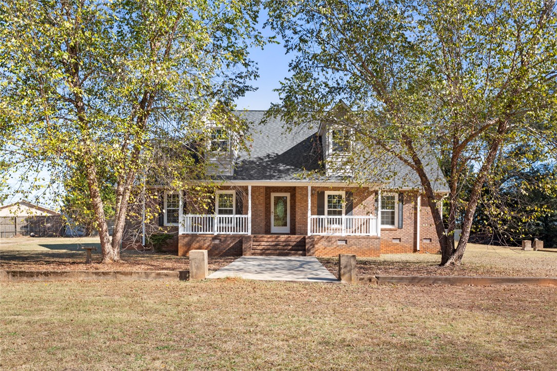 This charming home offers a welcoming facade with traditional brick and an inviting front porch.