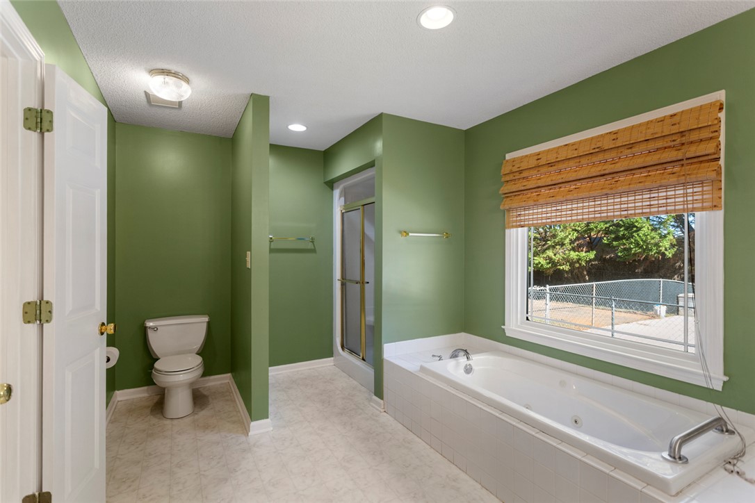 108 Ora Lane Anderson, SC 29625 - Photo 18 of 40 This spacious primary bathroom features a large soaking tub and a walk-in shower.