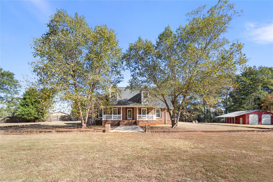 108 Ora Lane Anderson, SC 29625 - Photo 2 of 40 This charming home features a classic brick exterior and a welcoming porch, nestled amidst mature trees.