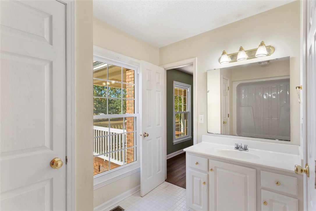 108 Ora Lane Anderson, SC 29625 - Photo 22 of 40 This bright bathroom features a single vanity, large mirror, and tiled flooring.