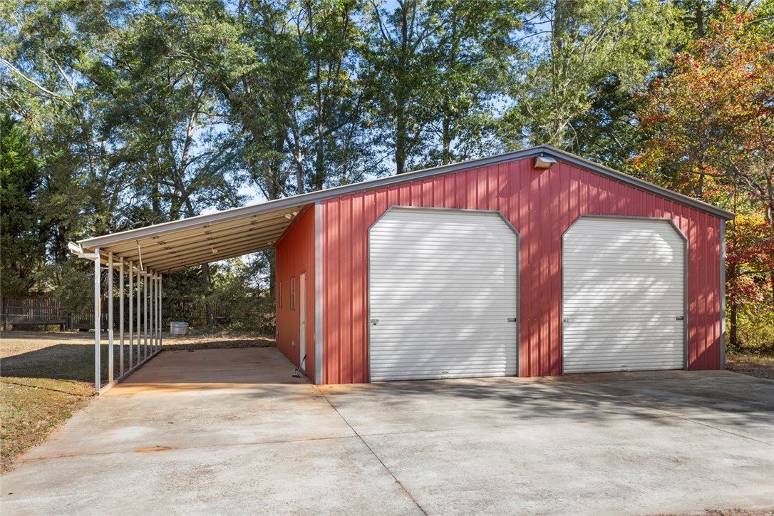 108 Ora Lane Anderson, SC 29625 - Photo 38 of 40 This metal building offers a convenient two-car garage and a spacious covered carport for additional parking or storage.