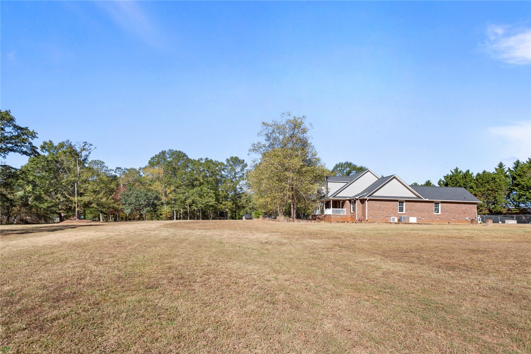 108 Ora Lane Anderson, SC 29625 - Photo 40 of 40 Expansive green space envelops a classic brick home with charming gable details, creating a serene environment.