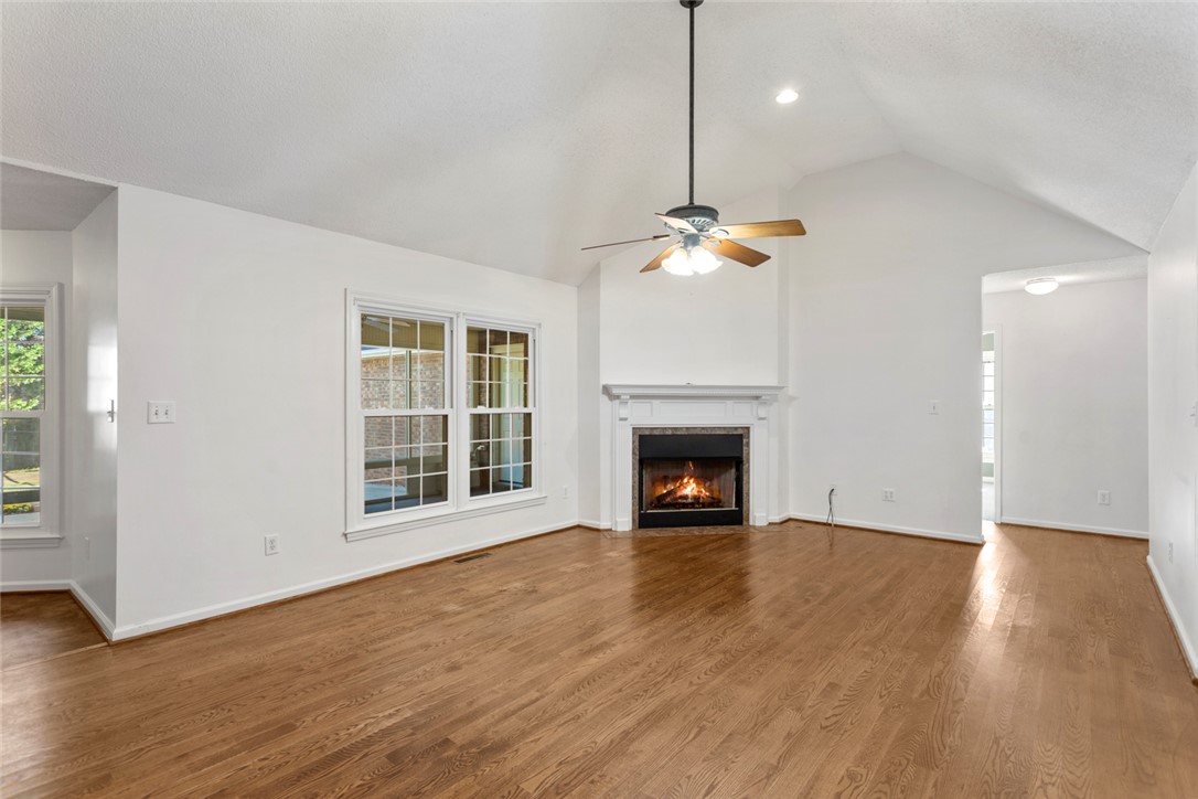 108 Ora Lane Anderson, SC 29625 - Photo 6 of 40 This bright living space features warm hardwood floors and a cozy fireplace, creating an inviting atmosphere.