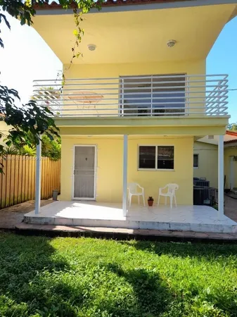 a view of a house with backyard and sitting area