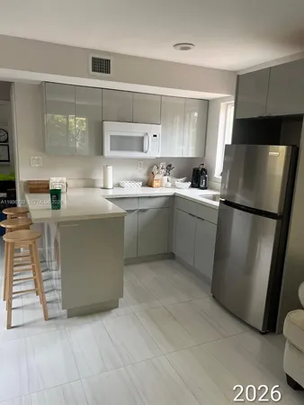 a kitchen with stainless steel appliances granite countertop a refrigerator a sink and a stove