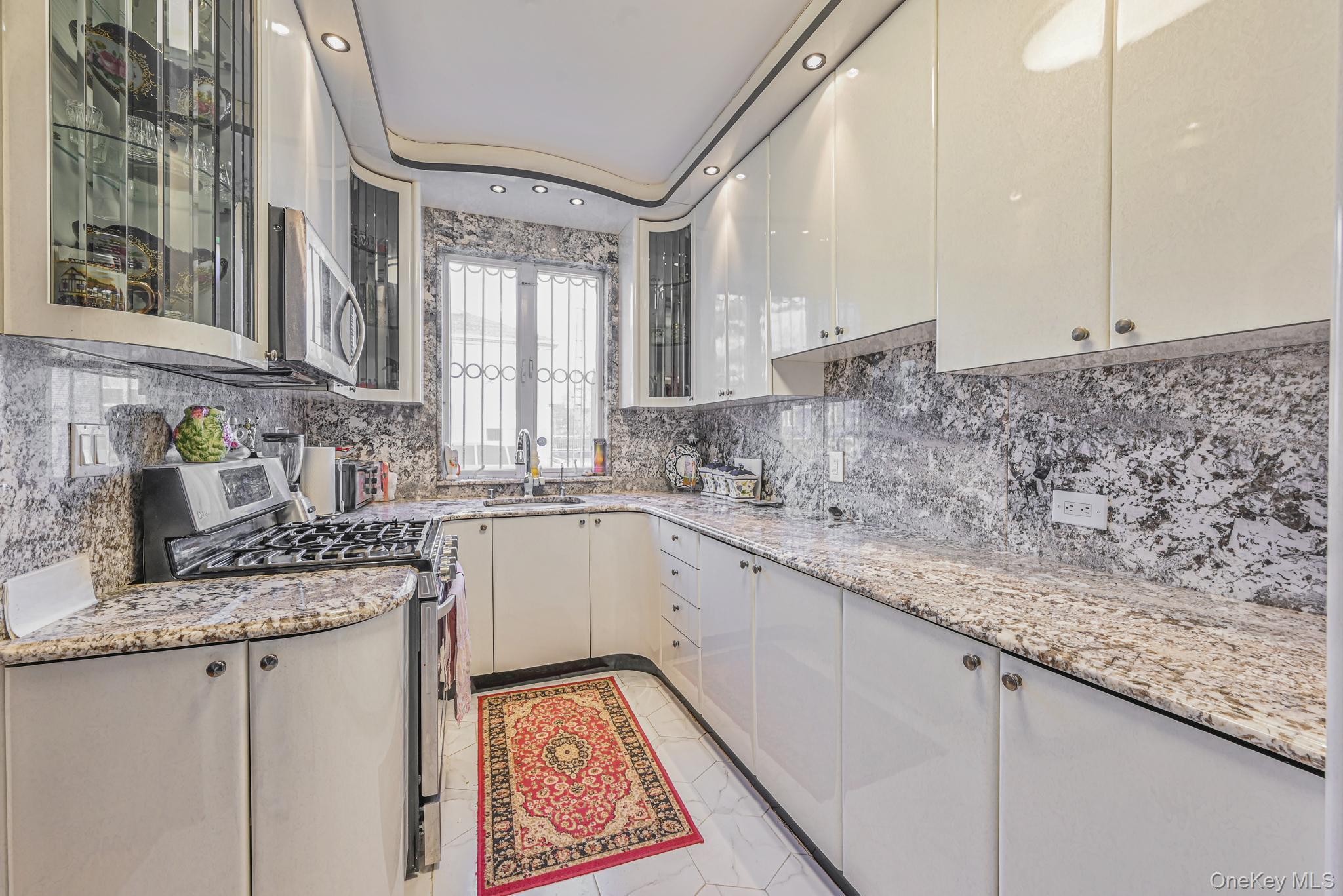 102-01 62nd Road Queens, NY 11375 - Photo 6 of 25 a kitchen with granite countertop a sink stove and cabinets