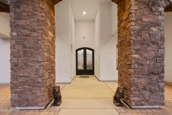 a view of a white house with a yard plants and large tree