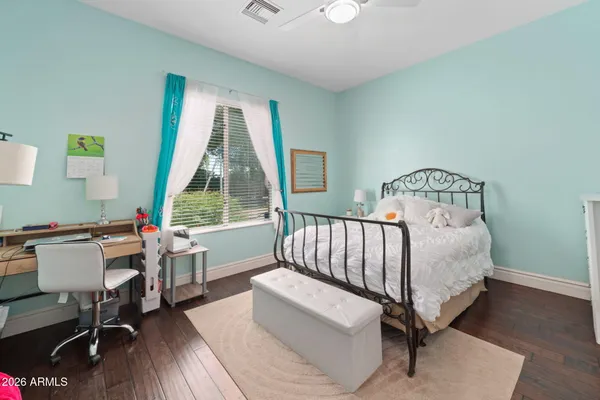 a view of a backyard with fence and a large tree