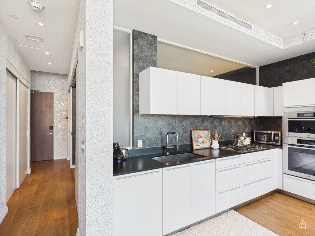 210 Lavaca Street, Unit 1809 Austin, TX 78701 - Photo 14 of 32 Kitchen featuring recessed lighting, white cabinetry, light wood-style flooring, modern cabinets, and dark countertops