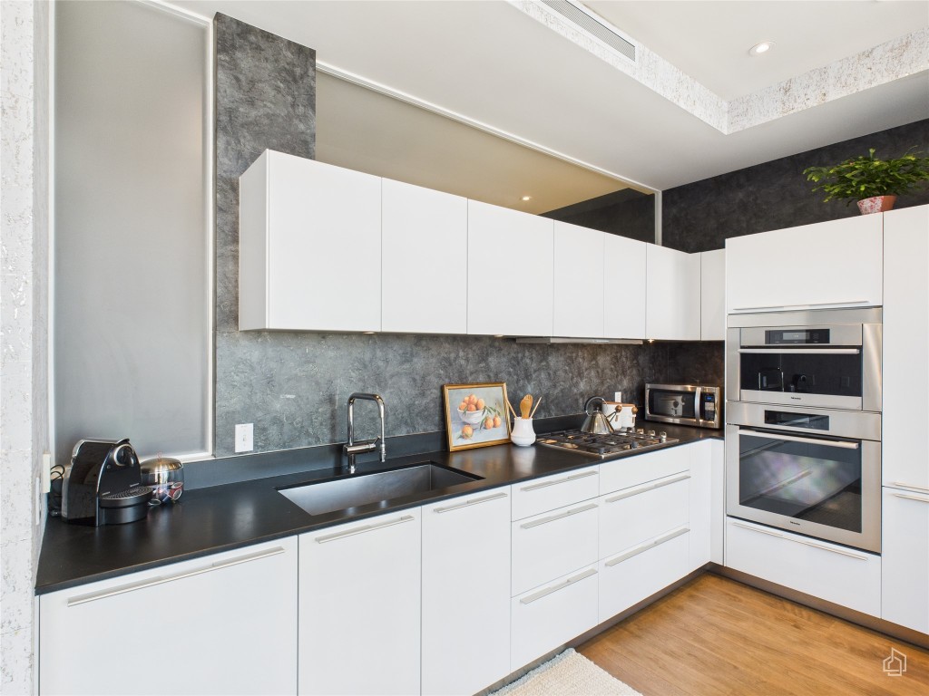 210 Lavaca Street, Unit 1809 Austin, TX 78701 - Photo 15 of 32 Kitchen featuring white cabinets, dark countertops, backsplash, and modern cabinets