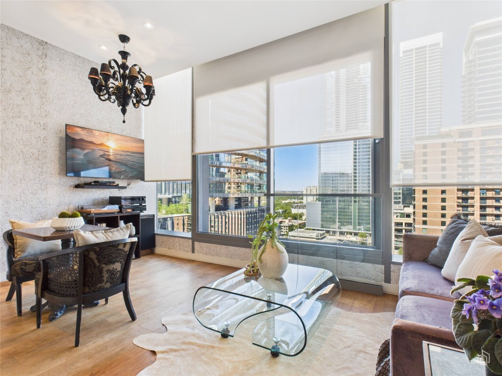 210 Lavaca Street, Unit 1809 Austin, TX 78701 - Photo 18 of 32 Living room featuring wood finished floors and a chandelier