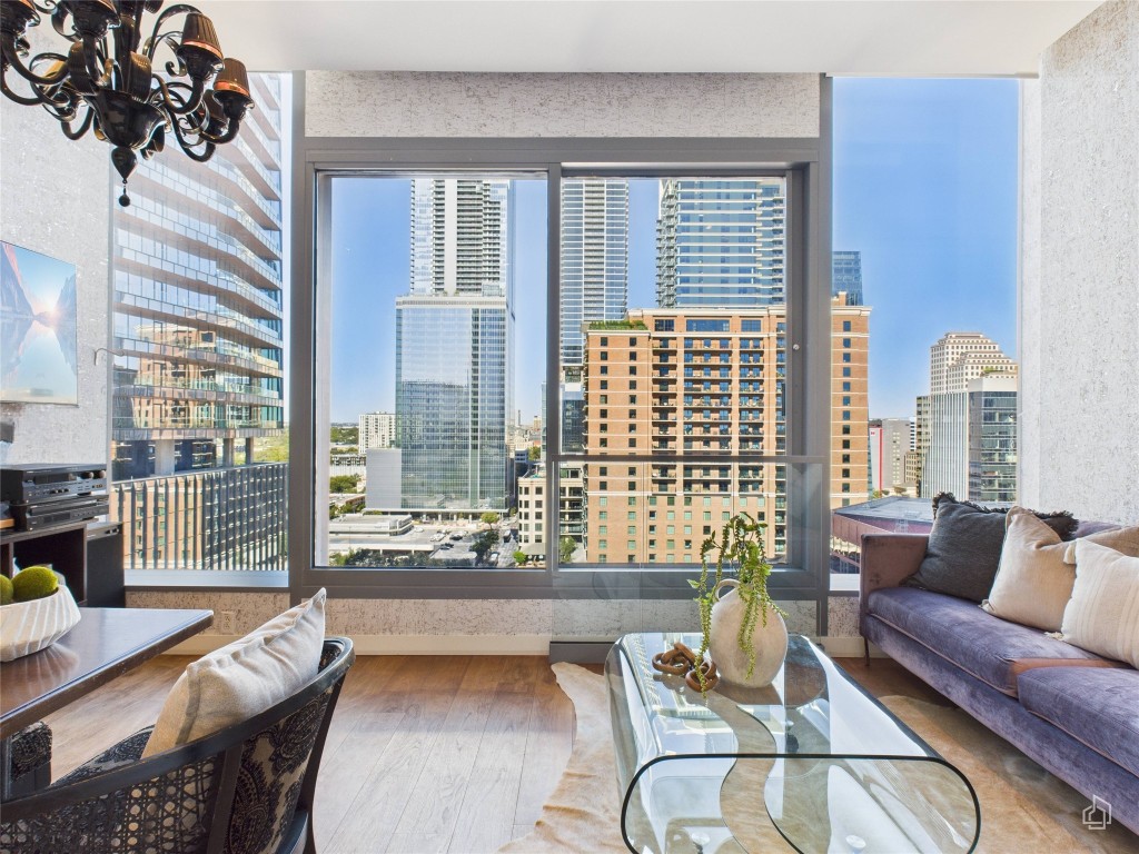 210 Lavaca Street, Unit 1809 Austin, TX 78701 - Photo 21 of 32 Living area featuring a city view, wood finished floors, and a chandelier