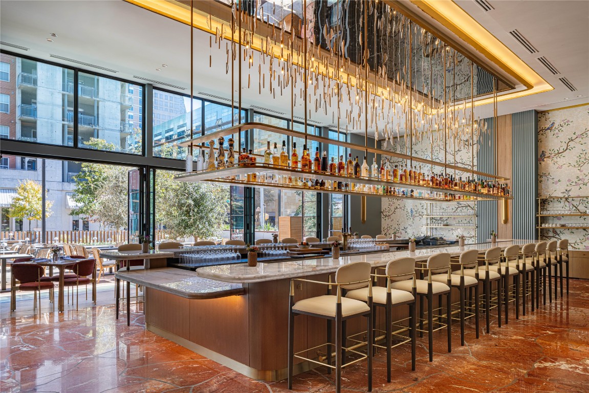 210 Lavaca Street, Unit 1809 Austin, TX 78701 - Photo 31 of 32 Indoor wet bar with light stone counters, wallpapered walls, and expansive windows