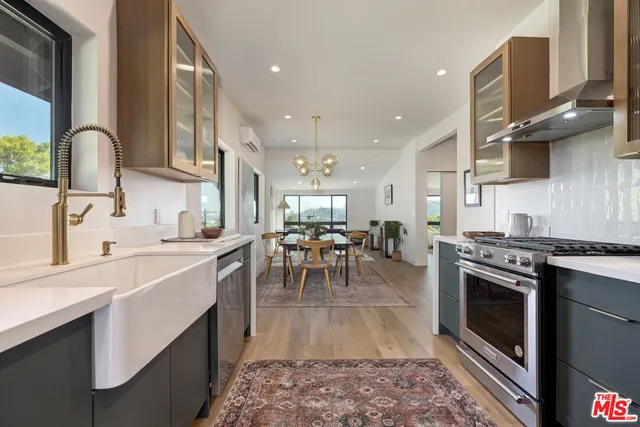 a kitchen with a stove a sink and cabinets
