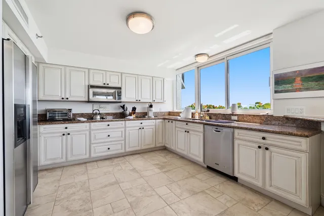 a kitchen with cabinets appliances a sink and a window