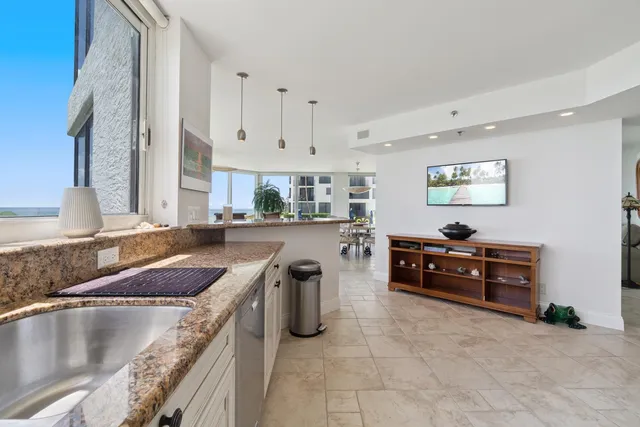 a kitchen with stainless steel appliances granite countertop a sink a stove and a refrigerator