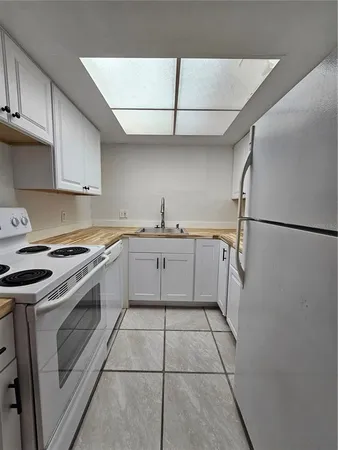 a kitchen with a sink a stove top oven and cabinets