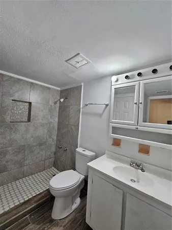 a bathroom with a sink a toilet and shower
