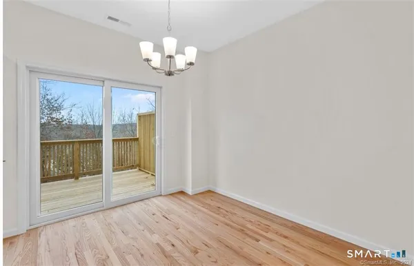 a view of a chandelier in big room with wooden floor