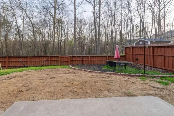 a view of a patio with table and chairs and wooden fence