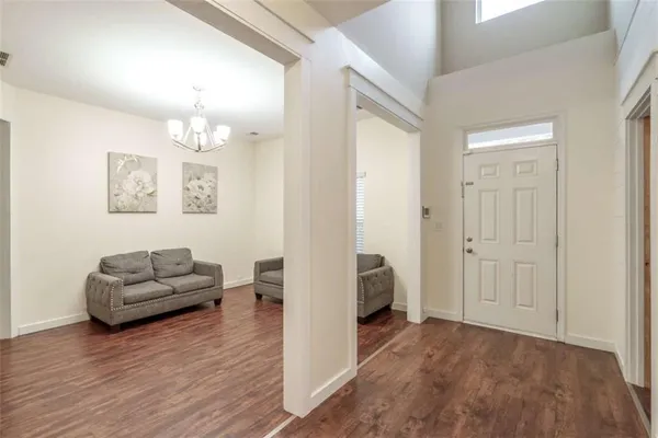 a living room with furniture and a wooden floor