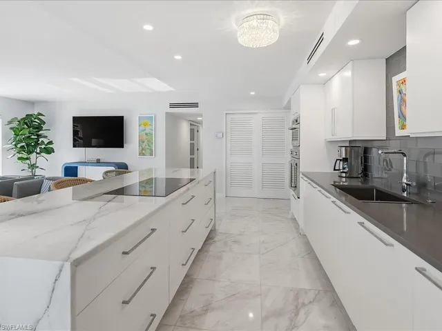 a kitchen with kitchen island a counter top space appliances and cabinets